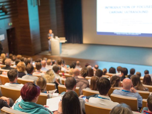 Ein Mann spricht zu Zuhörern in einer Hochschule