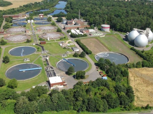 Drohnenbild der Kläranlage Düren-Merken, umgeben von Getreidefeldern, Wald und Teichen, in der Nähe einer Siedlung.