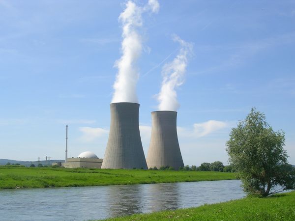 Kraftwerk an der Weser mit 2 Kühltürmen, aus denen Wasserdampf austritt.