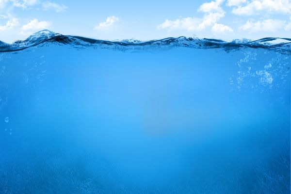 Unterwasseraufnahme, Wasserlinie mit wolkigem Himmel