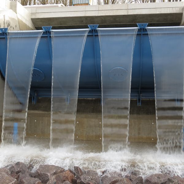 Bauwerk im Fluss, aus dem gerade Wasser fließt, getrennt in vier Wasserströme
