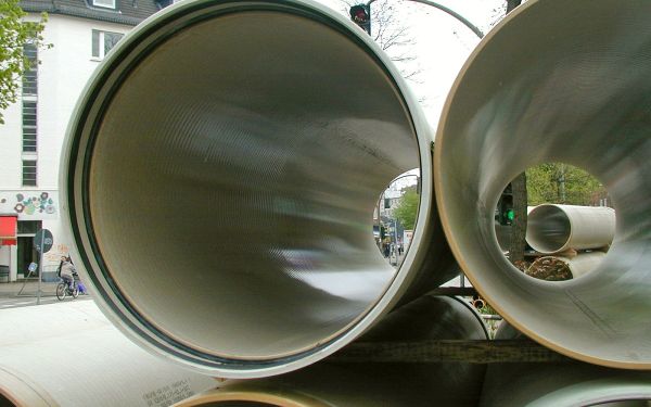 mehrere Abwasserrohre, die an einer Straße aufgestapelt übereinander liegen