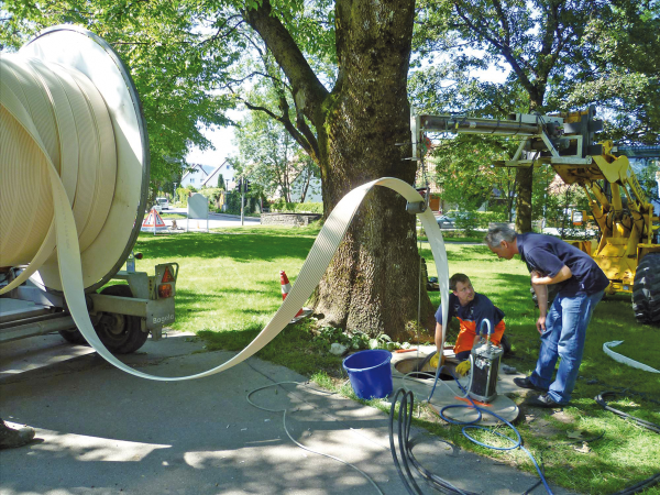Baustelle mit Personen, die einen Liner in den Kanal einziehen