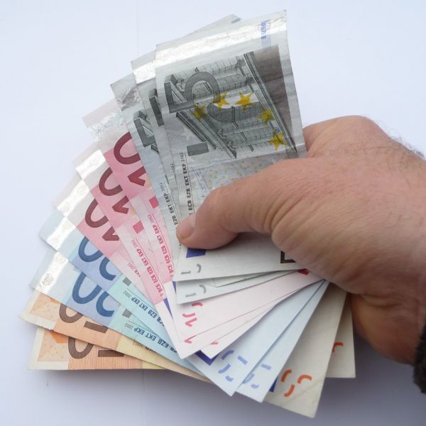 Eine Hand hält einige Geldscheine fest