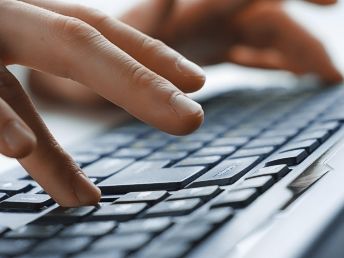 Nahaufnahme einer Tastatur mit einem Händepaar