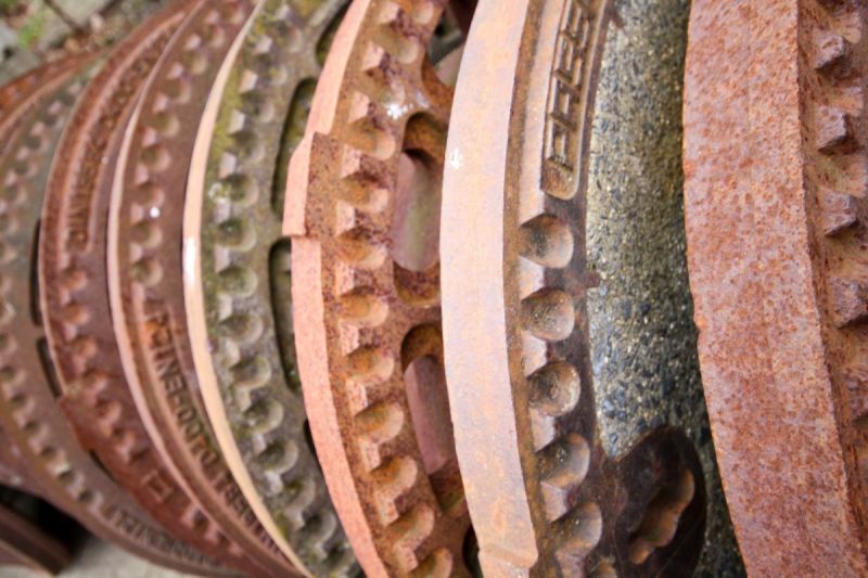 viele Kanaldeckel hintereinander in Reihe aufgestellt