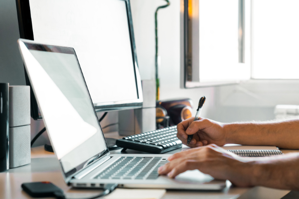Laptop, Mann sitzt vor Bildschirm