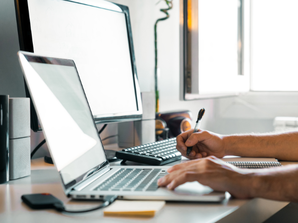 Laptop, Mann sitzt vor Bildschirm