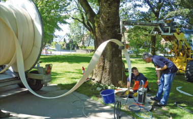 Baustelle mit Personen, die einen Liner in den Kanal einziehen