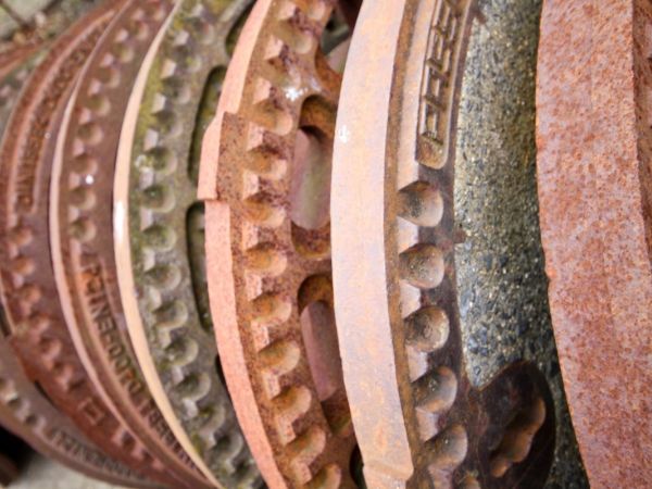 viele Kanaldeckel hintereinander in Reihe aufgestellt