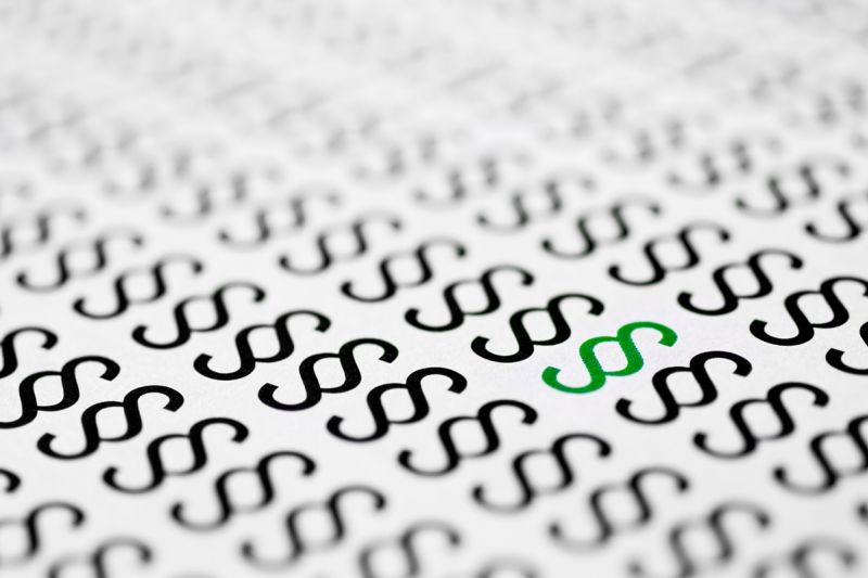 Ein grünes inmitten vieler schwarzen Paragrahenzeichen.